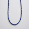 A studio shot of a women's 4mm lapis lazuli round bead necklace curved in a U-shape, showcasing the deep blue tonality and uniform bead size against a neutral background.
