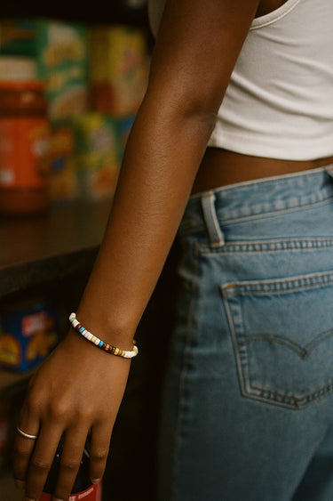 A lifestyle image of a model featuring the 4mm mixed gemstone heishi bead bracelet, demonstrating its sophisticated presence and colorful, handcrafted quality for everyday wear.
