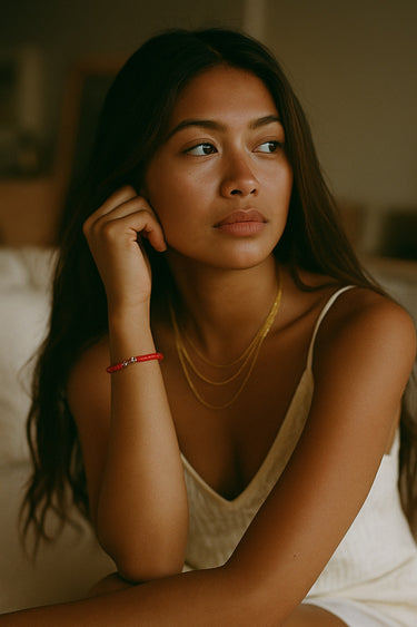 A lifestyle shot of a model wearing the 4mm red agate heishi bracelet, highlighting its versatile design and timeless appeal as a modern jewelry staple for layered looks.
