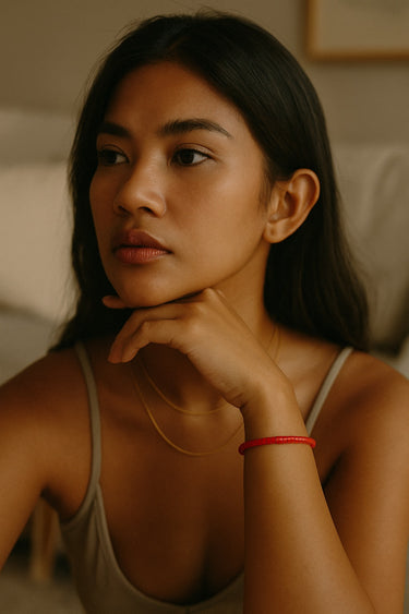 A close-up lifestyle image of a model featuring the 4mm red agate heishi bead bracelet, demonstrating its refined handcrafted quality and comfortable, stackable silhouette.
