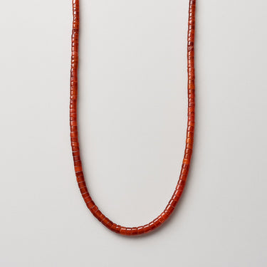 A professional studio hero shot of the women's 4x2mm red agate heishi necklace arranged in a U-shape against a neutral background, highlighting the uniform disc geometry and vibrant crimson saturation.

