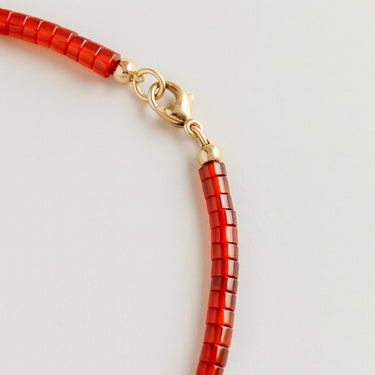 A macro detail view of the 4mm red agate heishi beads meeting professional-grade 14K gold-filled hardware, featuring a secure and high-polish lobster clasp.
