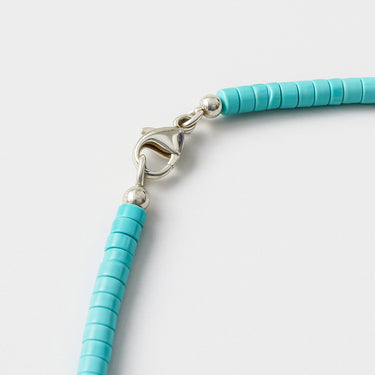 A detailed close-up of a high-polish sterling silver lobster clasp closure on the 4mm Blue Turquoise heishi necklace.

