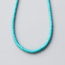 A 4mm Blue Turquoise heishi bead necklace arranged in a clean U-shape against a neutral background, highlighting its vibrant color and consistent bead shape.
