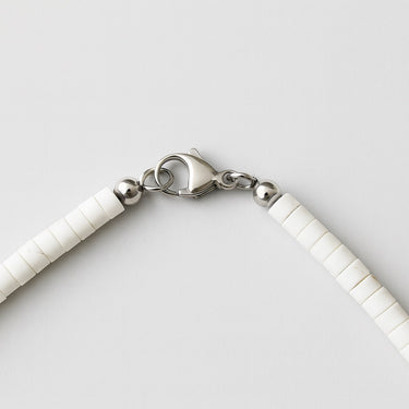 A macro detail view of the 4mm white turquoise heishi beads meeting professional-grade sterling silver hardware, featuring a secure and high-polish lobster clasp.
