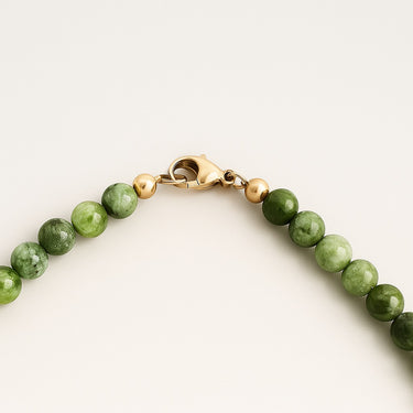 A macro detail shot of 6mm chrome diopside beads meeting professional-grade 14K gold-filled hardware, featuring a high-polish lobster clasp and modern, refined edge.
