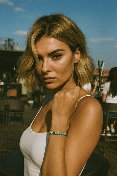 A lifestyle shot of a model wearing a 6mm handmade Millefiori glass bead bracelet, showcasing the vibrant multi-colored floral patterns and its effortless, stackable design for everyday luxury.
