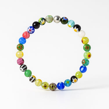 A studio hero shot of a 6mm Millefiori glass bead bracelet with a sterling silver accent, demonstrating its colorful artisanal aesthetic and timeless quality as a modern jewelry staple.
