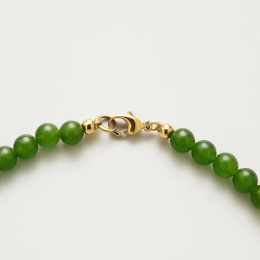 A macro close-up of the professional-grade 14K gold-filled lobster clasp closure on the 6mm Jade round bead necklace.
