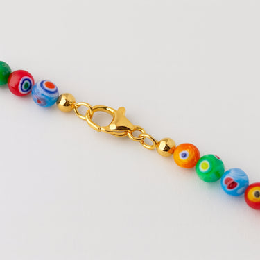 A close-up detail shot of 6mm Millefiori glass beads meeting professional-grade 14K gold-filled hardware, featuring a high-polish lobster clasp.
