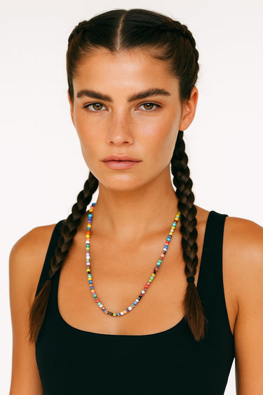 An editorial lifestyle portrait of a woman wearing the 6mm Millefiori glass necklace, emphasizing the piece's structural presence and vibrant, handmade texture.
