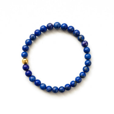 A studio hero shot of a 6mm blue lapis lazuli bead bracelet featuring a 14K gold-filled accent bead, highlighting the rich golden pyrite inclusions within the natural stones.
