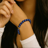 A portrait lifestyle shot of a model wearing the 6mm lapis lazuli bracelet, demonstrating its sophisticated presence and timeless handcrafted quality as a modern staple piece.
