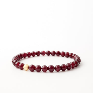 A perspective studio shot of the 6mm garnet bead bracelet, emphasizing the uniform round stones and the elegant contrast of the gold-filled metallic accent.
