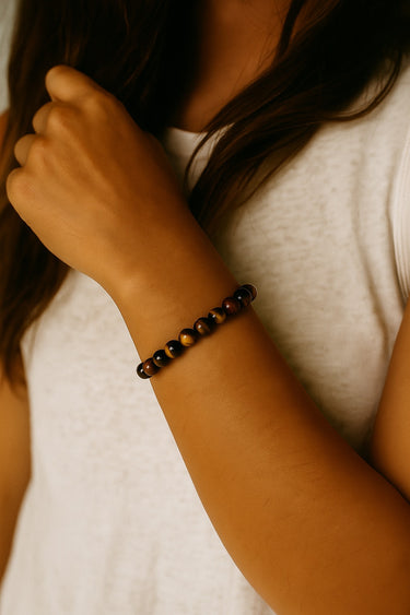 A close-up lifestyle shot of the 6mm Tiger's Eye bead bracelet on a model's wrist, highlighting its sophisticated presence and modern luxury aesthetic when paired with neutral tones.
