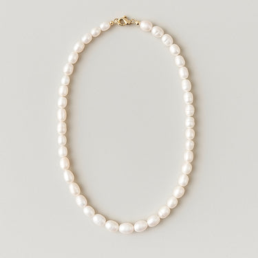 A studio shot of the women's freshwater pearl necklace arranged in a clean oval shape against a neutral background, showcasing the consistent size and luster of the 7-8mm pearls.

