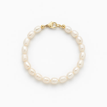 A studio hero shot of a 7-8mm natural white baroque freshwater pearl bracelet with a 14K gold-filled clasp, highlighting the individual character and high-shine finish of each pearl.
