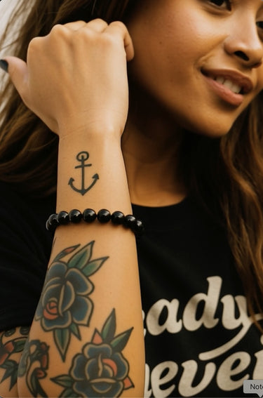 A close-up lifestyle shot of the 8mm gloss black onyx bead bracelet on a model's wrist, highlighting the architectural silhouette and deep black luster of the polished stones.
