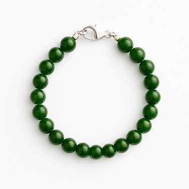 A studio hero shot of an 8mm green jade bead bracelet arranged in a clean circular form, highlighting the uniform size and rich luster of the semi-precious stones.
