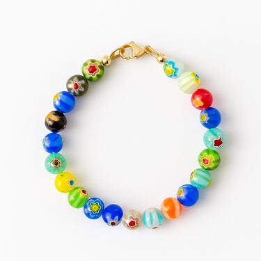 A studio hero shot of an 8mm handmade Millefiori glass bead bracelet with a 14K gold-filled clasp, featuring vibrant, multi-colored floral patterns for a unique artisanal look.
