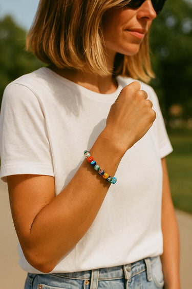 A lifestyle view of the 8mm Millefiori glass bead bracelet on a model in a white t-shirt, demonstrating its ability to add a sophisticated pop of color to neutral everyday wear.
