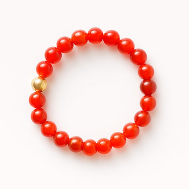 A studio hero shot of an 8mm red agate bead bracelet featuring a single 14K gold-filled accent bead, highlighting the high-polish luster and timeless versatile design.
