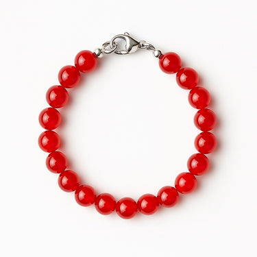 A studio hero shot of an 8mm natural red agate bead bracelet with a sterling silver lobster clasp, emphasizing the rich uniform color and timeless handcrafted quality.
