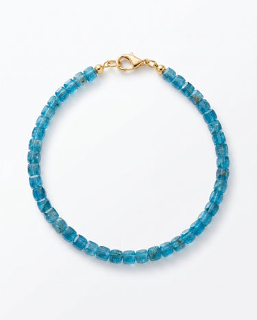 A studio product shot of a women's AAA natural teal blue apatite faceted 2-3mm cube beads bracelet with 14k gold-filled lobster clasp on a white background.