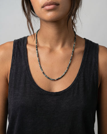 Woman is wearing a black tank top and a cube faceted tourmaline beaded necklace gold accents throughout the necklace against a neutral background