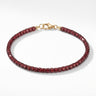 A studio hero shot of a women's 3mm natural faceted garnet cube bead bracelet with a 14K gold-filled clasp, highlighting the light-catching facets and deep wine-red gemstone tones.