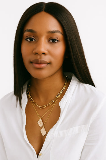 A focused lifestyle shot of a model wearing the Gold Chunky Chain necklace layered with gemstone pendants, emphasizing its structural presence and refined edge.
