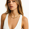 A lifestyle shot of a model wearing the Gold Chunky Chain necklace against a white tank top, highlighting its high-polish finish and bold architectural links.
