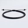 Studio product shot of adjustable black gloss onyx heishi bracelet with sliding knot closure, with gemstone and sterling silver dangles.