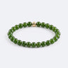 A studio product shot of a women's 6mm green jade bead bracelet featuring a single 14K gold-filled accent bead.