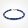 A studio product shot of a women's 4mm natural lapis lazuli heishi bead bracelet with a 14K gold-filled clasp, highlighting the deep royal blue gemstone tones and sleek disk shape.