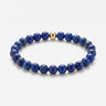 A studio product shot of a women's 6mm blue lapis lazuli bead bracelet featuring a single 14K gold-filled accent bead.