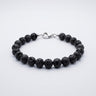 A studio product shot of a women's 8mm natural black lava bead bracelet with a sterling silver lobster clasp.