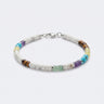 A studio product shot of a 4mm mixed gemstone heishi bracelet featuring white turquoise, tiger's eye, and amethyst, with sterling silver flat rondel beads for a refined, colorful aesthetic.