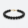 A studio product shot of a women's 8mm natural matte onyx bead bracelet with a 14K gold-filled lobster clasp.