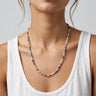 Colorful 4mm round millifiori beaded necklace worn by a woman in a white tank top against a neutral background