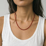 woman with a white tank top wearing 4mm red agate beaded necklace against a plain background