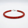 A studio product shot of a women's 4mm natural red agate heishi bead bracelet with a sterling silver clasp, highlighting the vibrant crimson tones and uniform disk-shaped stones.
