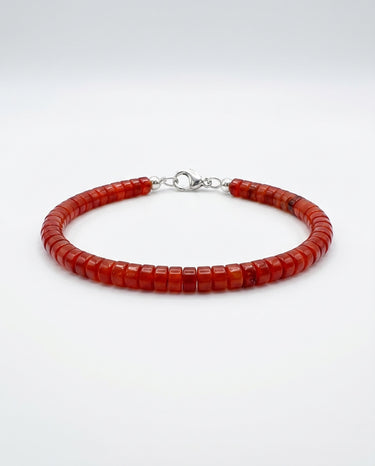 A studio product shot of a women's 4mm natural red agate heishi bead bracelet with a sterling silver clasp, highlighting the vibrant crimson tones and uniform disk-shaped stones.