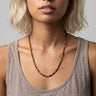 A woman wearing a 4mm tiger's eye round bead necklace, showcasing the warm tones of the stones against a white tank top for an editorial, sophisticated look.