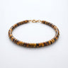 A studio product shot of a women's 4mm natural tiger's eye heishi bead bracelet with a 14K gold-filled clasp, highlighting the rich golden-brown chatoyancy and disk shape.
