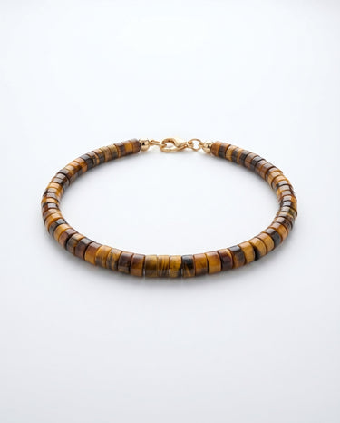 A studio product shot of a women's 4mm natural tiger's eye heishi bead bracelet with a 14K gold-filled clasp, highlighting the rich golden-brown chatoyancy and disk shape.
