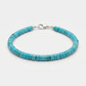 A studio product shot of a 4mm turquoise heishi bead bracelet with a sterling silver lobster clasp, showcasing the uniform disk shape and natural semi-precious stone texture.
