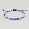 A beaded adjustable bracelet with a blue and white checkered pattern, accented with gold spacer beads, on a light gray background.