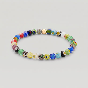 A studio product shot of a 6mm handmade Millefiori glass bead stretchy  bracelet featuring a 14K gold-filled accent bead, showcasing vibrant multi-colored floral patterns.