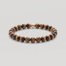 A studio product shot of a women's 6mm tiger's eye bead stretchy bracelet featuring a single sterling silver accent bead.